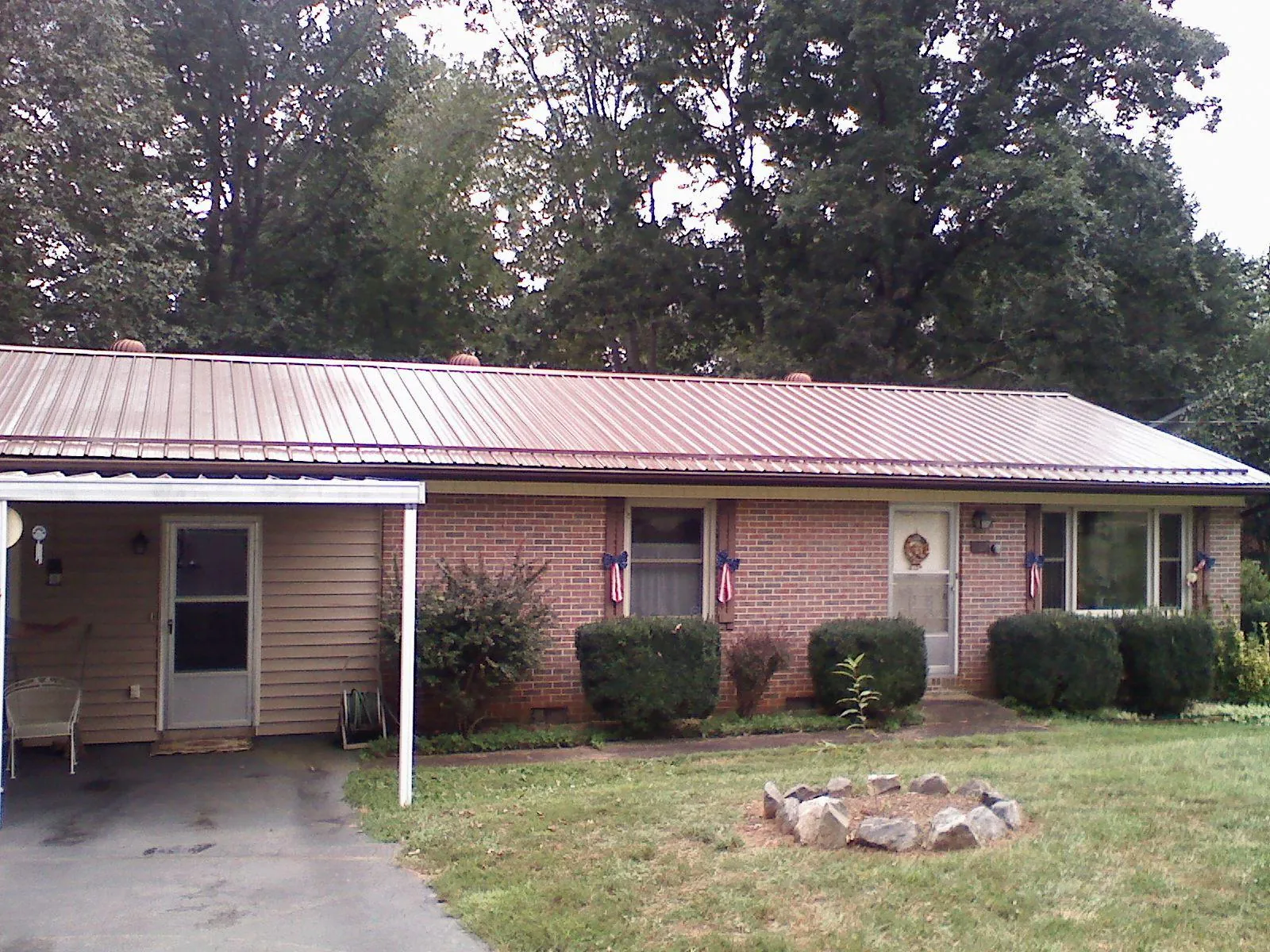 Bronze metal roof and carport on a brick ranch home — Roof Repair work by our crew in Thompson Ridge